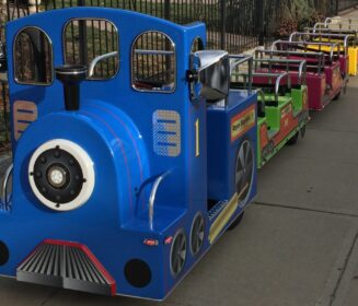 A trackless train on a paved sidewalk