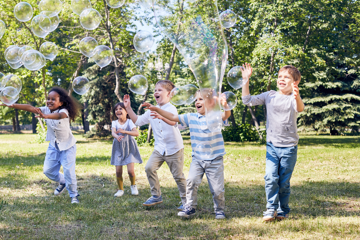 A group of kids having fun with bubbles, during foam and bubble party rentals from Mike's Trackless Trains