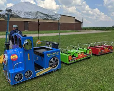 Kids having fun jumping in a bouncy house and enjoying Train Ride Party Rental in Peoria IL