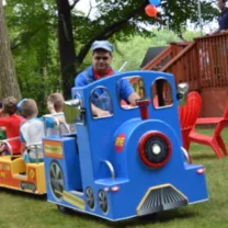 A trackless train being driven by a party attendant, as part of the Party & Event Rentals offered by Mike's Trackless Trains