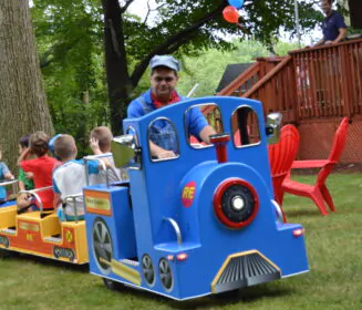 A trackless train being driven by a party attendant, as part of the Party & Event Rentals offered by Mike's Trackless Trains